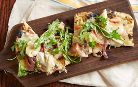 brown board with pizza of prosecution and arugula