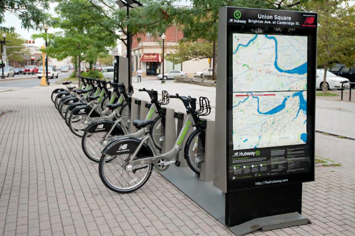 Boston Hubway station with several silver and lime green bikes available for rent